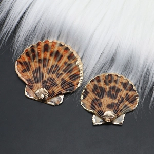 Dettaglio di ciondoli a conchiglia leopardata con eleganti bordi placcati oro per DIY