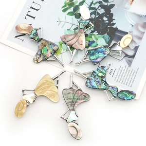 Elegant silver dancer brooch with iridescent abalone shell inlay on fashion magazine