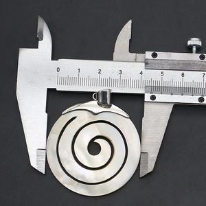 Makroansicht eines 45mm spiralförmig geschnitzten Muschel-Anhängers mit Messschieber