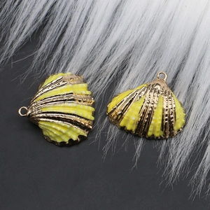 Close-up of yellow shell-shaped charms with gold plating for handmade DIY jewelry