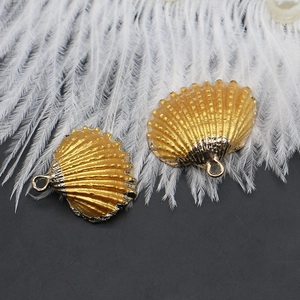 Close-up of gold-plated scallop shell pendants for DIY jewelry with detailed metallic texture