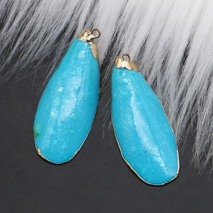 Vue macro de pendentifs en coquillage bleu ciel avec placage d'or et texture de pierre naturelle