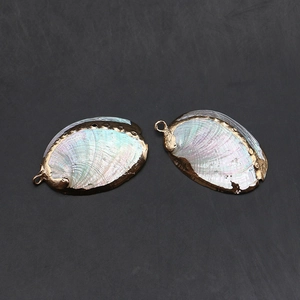 Détail de breloques en nacre d'abalone à l'éclat irisé et aux bords en métal doré