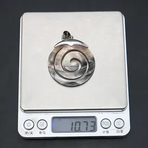 Schwarzer Muschel-Spiralanhänger mit 10,73 g auf einer silbernen Digitalwaage zur Probe