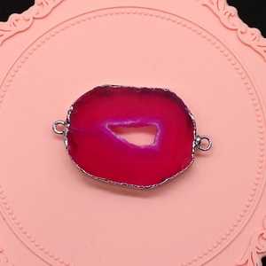 Macro detail van natuurlijke fuchsia agaat connector met zilveren rand voor DIY sieraden