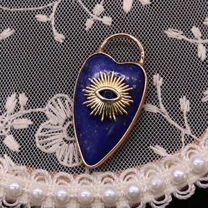 Close-up of heart-shaped lapis lazuli pendant with evil eye motif on lace fabric