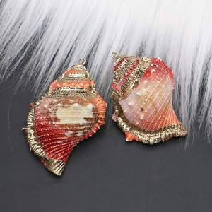 Detail of natural seashell pendants with gold plated edges and orange striped texture