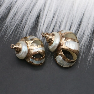 Close-up of DIY natural seashell pendants with golden electroplated edges for jewelry