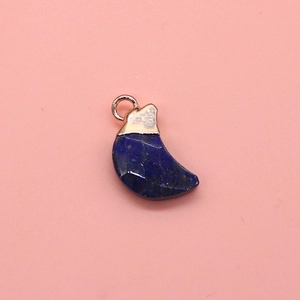 Macro detail of crescent moon blue turquoise pendant with faceted finish and gold clasp