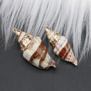 Macro detail of natural shell pendants with gold-plated edges and metal loops for DIY jewelry