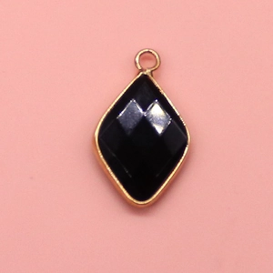 Detailed close-up of faceted black stone pendant with elegant gold plated metal frame