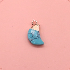 Macro detail of crescent moon blue turquoise pendant with elegant rose gold metal loop