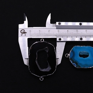 Detail van natuurlijke agaat schijf connector met dubbele ringen en verzilvering bij de schuifmaat