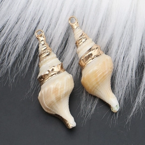 Detail of natural seashell pendants with elegant gold-plated edges and hanging loops
