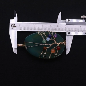 Detailweergave van de lengte van een handgemaakte levensboom hanger met een schuifmaat