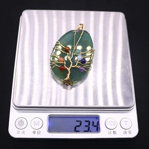 Detail van een handgemaakte levensboom hanger op een weegschaal van 23,4 gram