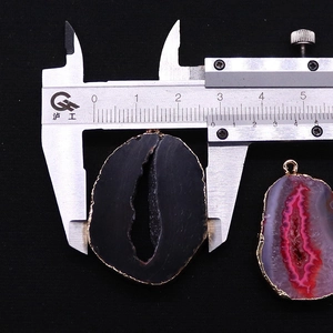 Meting van de 2,8cm breedte van een onregelmatige agaat hanger met gouden metalen rand