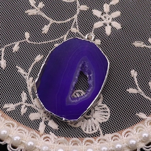 Macro detail of natural purple agate druzy slice pendant with silver plated edging