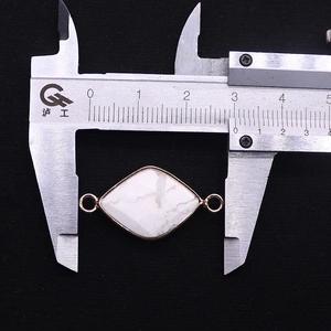 Macro view of natural white stone diamond connector measuring 21mm by 13mm