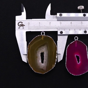 Macro shot of natural agate slice pendants showing 2.8cm width measured with a caliper