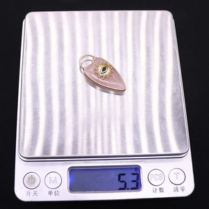 Detail showing pink natural stone heart pendant weighing 5.3g on a digital scale