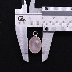 Detail shot of a 13mm pink quartz pendant with gold plated edge measured by a caliper