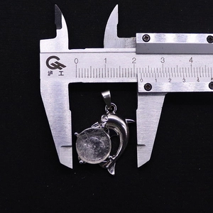 Detail view of the whale pendant width measurement using a vernier caliper tool