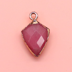 Detail of pink faceted shield stone pendant with gold plated metal edges and bail