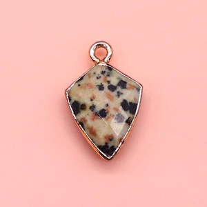 Macro detail of faceted shield-shaped Dalmatian Jasper pendant with rose gold plating