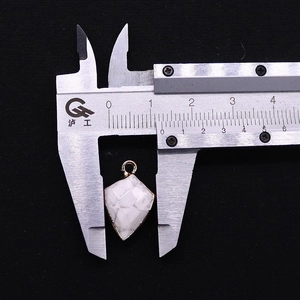 Detailed view of faceted white stone shield pendant measured with 13mm calipers
