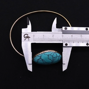 Macro shot of gold-plated bracelet with a 3.2cm oval turquoise stone and size measurement