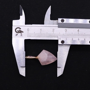 Macro d'un pendentif en quartz rose facetté avec crochet doré mesurant 25mm sur fond noir
