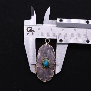 Measuring width of rose quartz pendant with turquoise inlay using a digital caliper