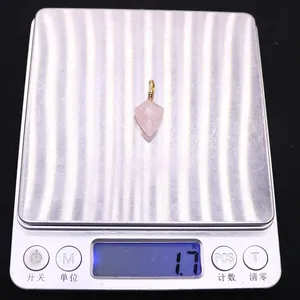 Vue macro d'un pendentif en quartz rose facetté sur une balance pesant 1,7 gramme