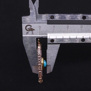 Macro view of 8.8mm thickness measurement for oval stone pendant with gold metal detail