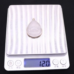 Detailed view of teardrop natural stone pendant on scale weighing 12.0 grams