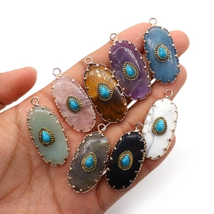 Handheld collection of oval gemstone pendants with turquoise accents and metal edges