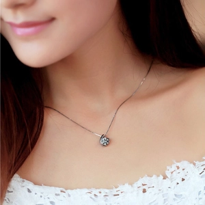 Elegant spiral silver necklace with round zircon pendant worn by a female model