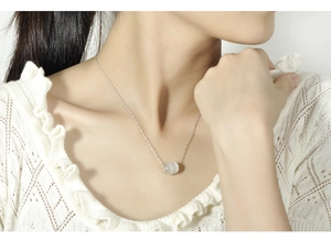 Detail of silver water wave chain necklace with cat eye opal cylinder bead pendant