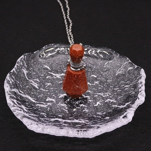 Détail du pendentif bouteille d'huile essentielle en pierre dorée avec chaîne argent
