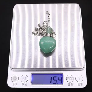 Detailed view of heart-shaped green quartz pendant weighing 15.4g on a digital scale