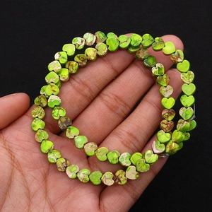 Macro detail of heart-shaped green imperial stone beads with natural brown vein textures