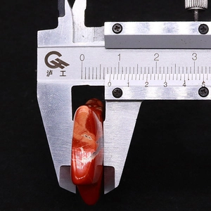 Detail showing caliper measurement of red natural stone star bead thickness of 8.8mm