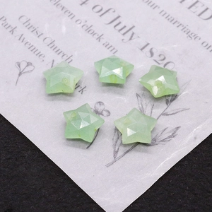 Close-up of five light green star-shaped faceted natural stone beads for DIY jewelry