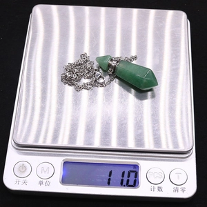 Nahaufnahme eines grünen Parfümflaschen-Anhängers mit einem Gewicht von 11,0 g auf der Waage