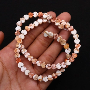 Dettaglio di perle in pietra naturale a forma di cuore con venature per gioielli DIY