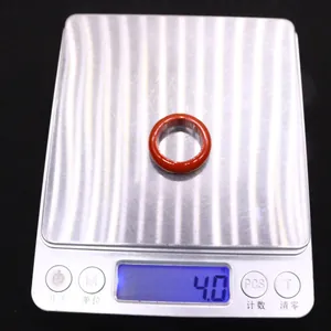 Flat round red agate gemstone ring displayed on digital scale weighing 4.0 grams