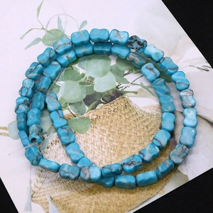 Macro view of bright blue butterfly-shaped turquoise beads with natural mineral texture