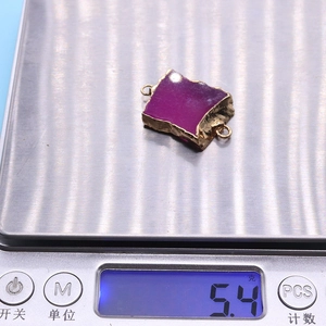 Detailweergave van het 5,4g gewicht van de paarse agaatsteen connector op de weegschaal