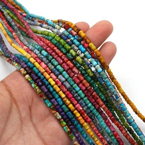 Perles en pierre d'empereur colorées en forme d'os pour bracelets DIY présentées en main